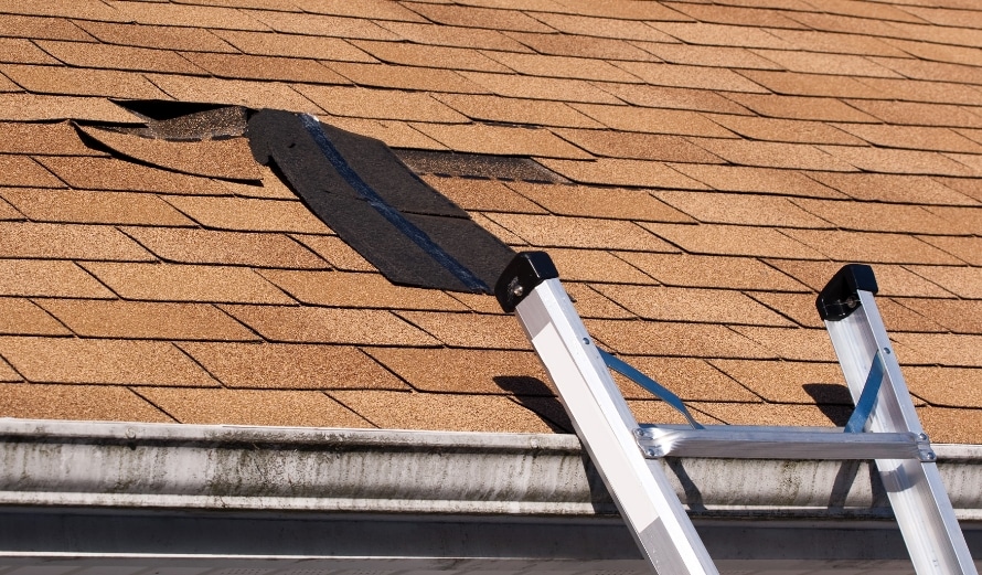 Image of a ladder layed against a residential home that needs damaged and missing shingles repaired.