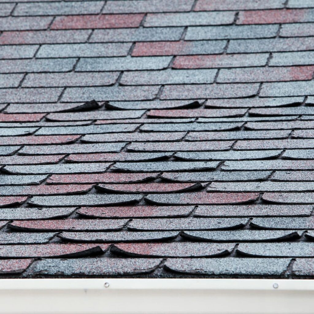 An image of a roof's shingles peeling. Another obvious sign of a needed roof replacement.